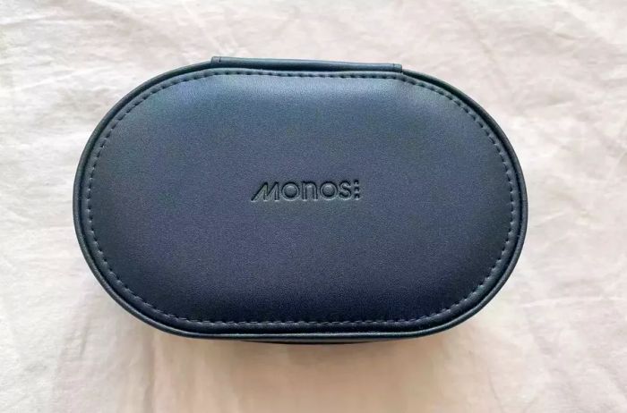 Monos Travel Jewelry Case closed and resting on a bed