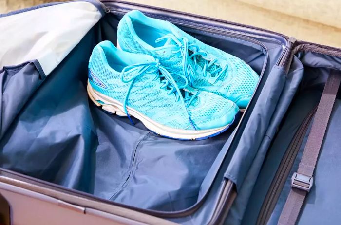 Lively blue athletic shoes placed within the Béis Hardside Luggage Set