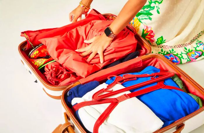 A person organizing items inside a Delsey CHATELET AIR 2.0 CARRY-ON - 21