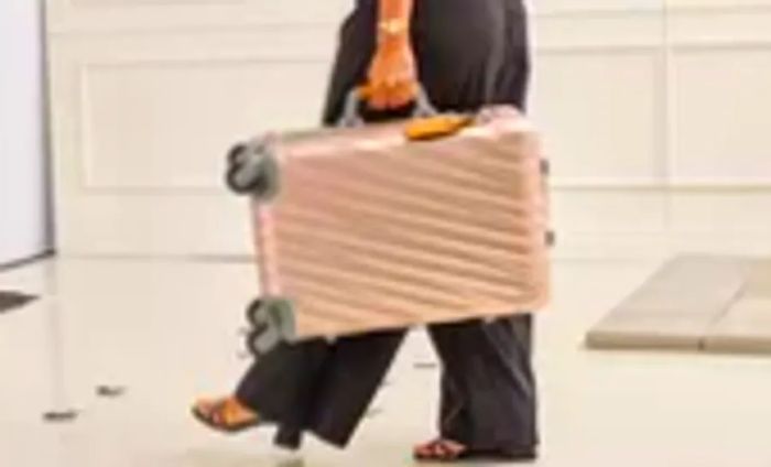 An individual holding the TUMI 19 Degree Aluminum International Carry-on