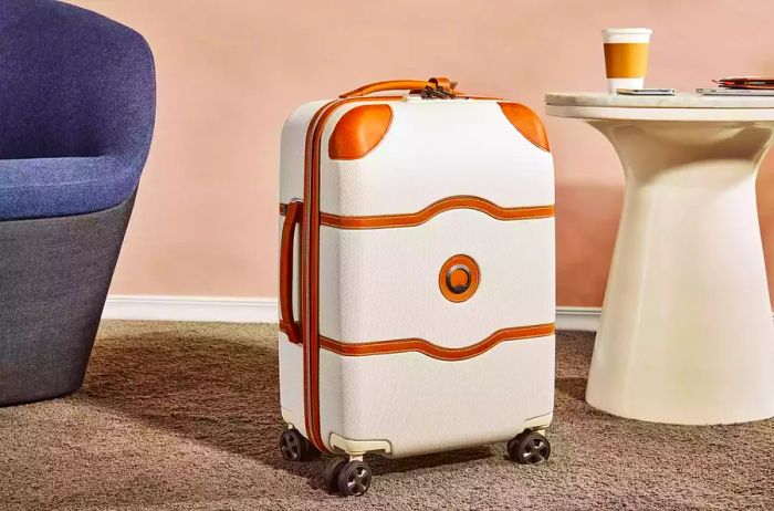 Delsey Chatelet Air 2.0 21-inch Carry-on Spinner showcased between a chair and a side table