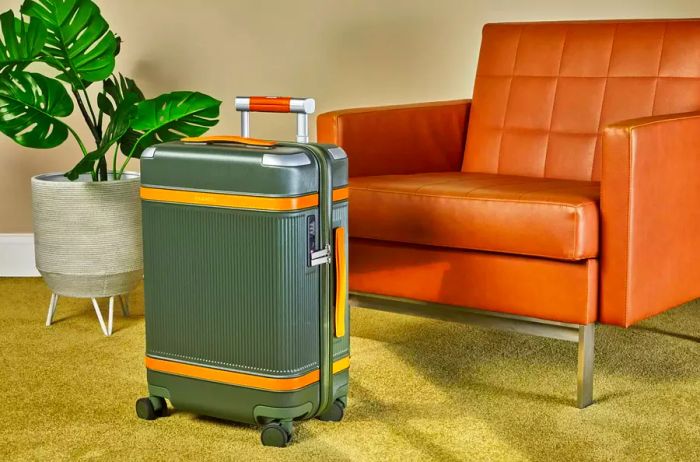 Paravel Aviator Carry-On Plus positioned next to a chair and a plant on a carpet