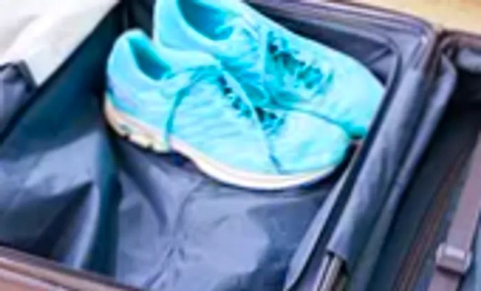 Vibrant blue athletic shoes nestled inside the Béis Hardside Luggage Set