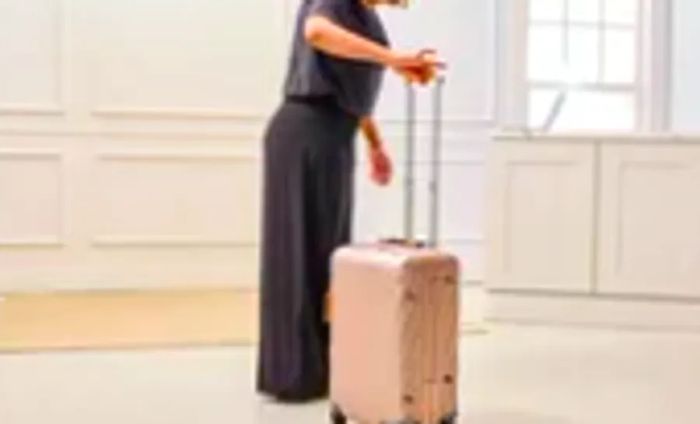 An individual making use of the TUMI 19 Degree Aluminum International Carry-on