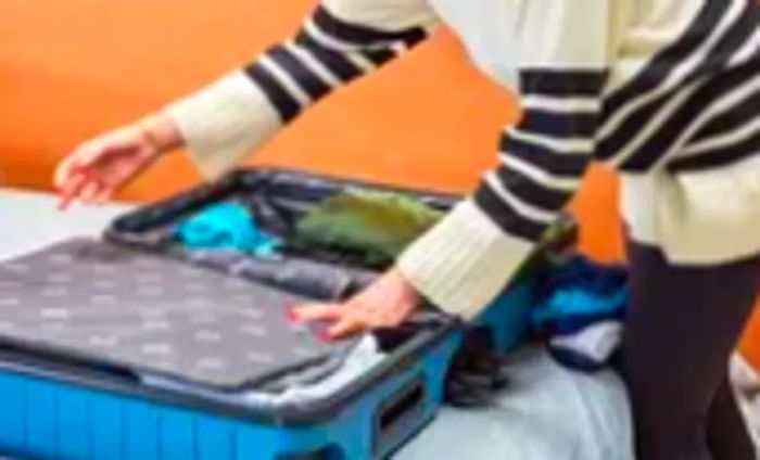 A person organizing items in the Away Luggage Set