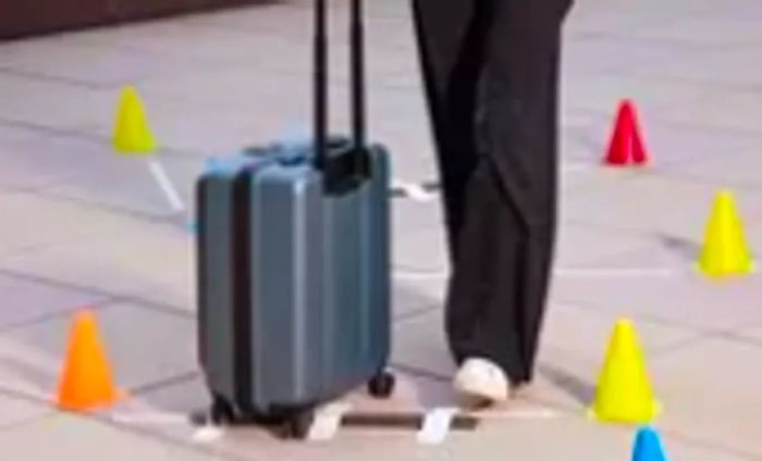 Person navigating the Coolife ABS+PC Spinner Trolley through a line of cones