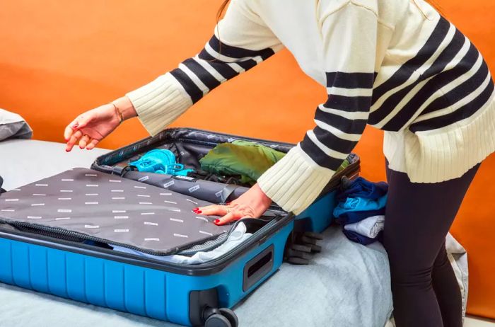 A person organizing their items into the Away Luggage Set