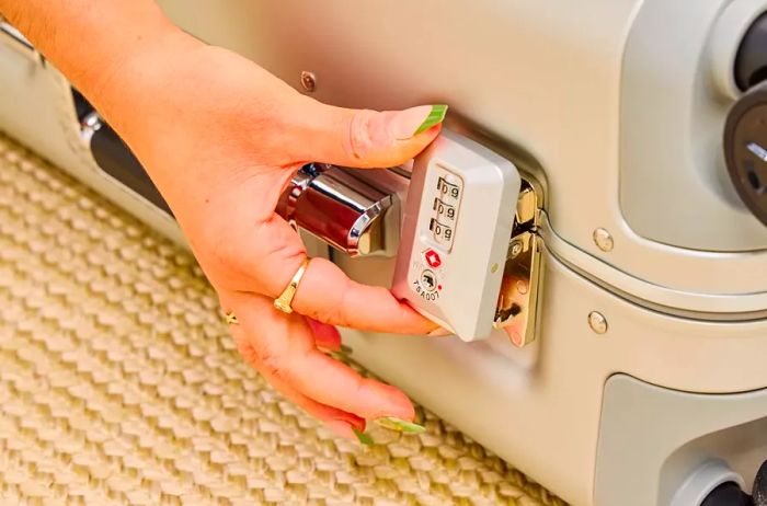 A person secures the lock on the Zero Halliburton Classic Aluminum 3.0 International Carry-on 33L