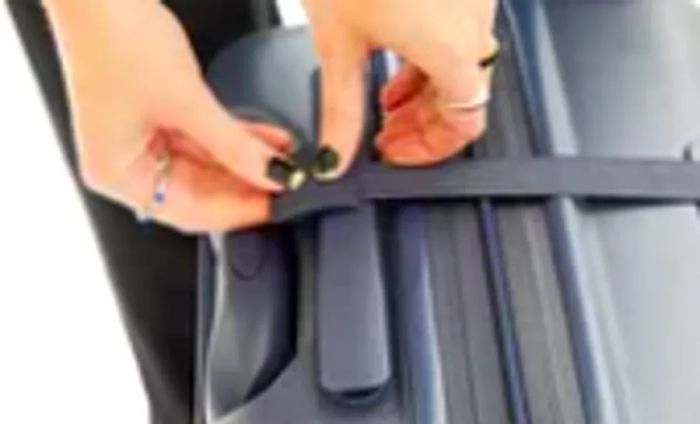 Close-up shot of hands securing a strap on the Béis Hardside Luggage Set