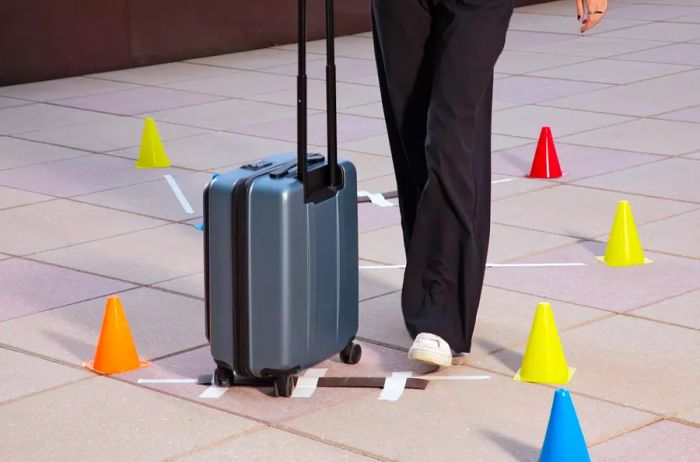 Person maneuvering the Coolife ABS+PC Spinner Trolley through a series of cones