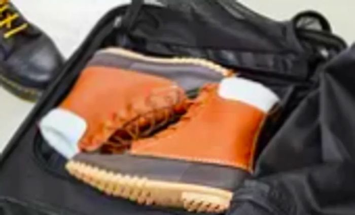 Boots stowed inside the Ogio Terminal Travel Bag