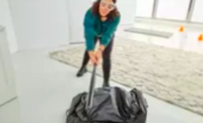 Woman striking the Thule Chasm Wheeled Duffel 32