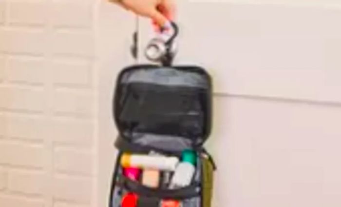 A person drapes the Aer Travel Kit 2 over a doorknob