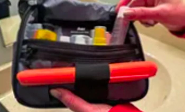 A person organizes travel items inside the Aer Travel Kit 2