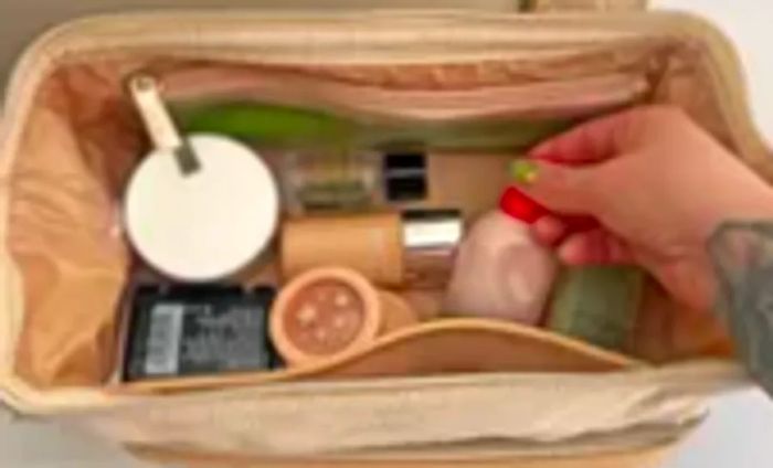 Someone adds a toiletry item to the Beis The Dopp Kit travel pouch