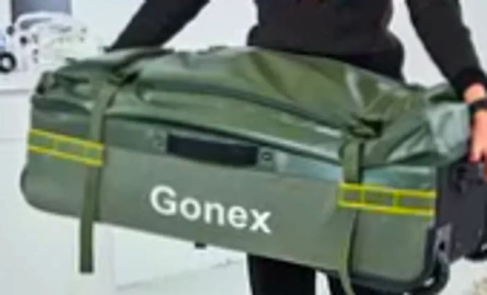 Individual carrying the Gonex Rolling Duffel Bag With Wheels