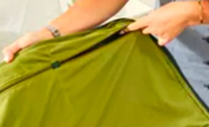 A person opens the pocket of the Away The Outdoor Rolling Duffel 85L