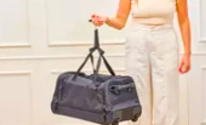 A traveler checks the weight of the Solo Leroy Rolling Duffel