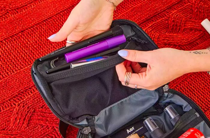 A person organizes travel essentials inside the Aer Travel Kit 2