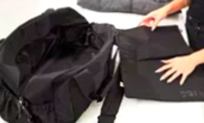 A person displaying a removable compartment bag from the Beis The Sport Duffle