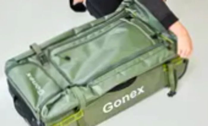 Person closing the Gonex Rolling Duffel Bag With Wheels