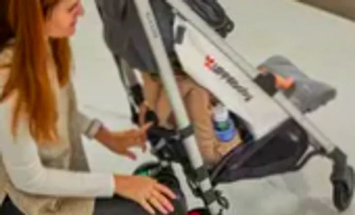 A person setting the JuJuBe Zealous Backpack onto a stroller