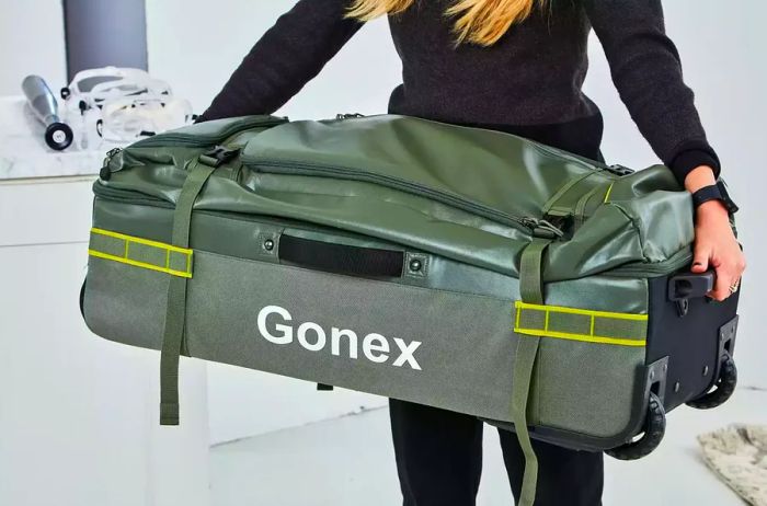 Individual lifting the Gonex Rolling Duffel Bag With Wheels