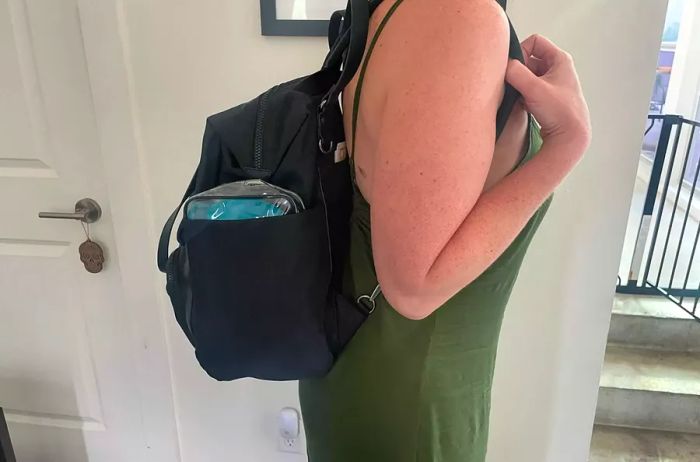 A person is seen wearing a black backpack