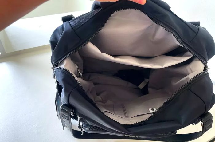 A black backpack is opened to reveal its interior