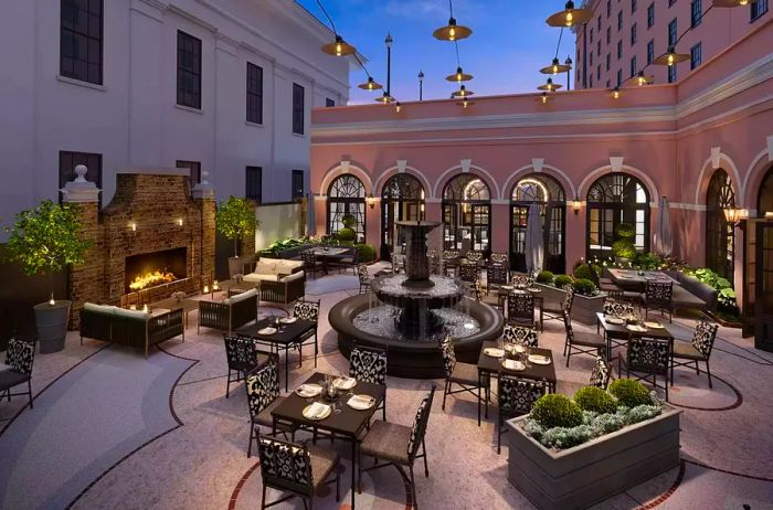 The Hotel Courtyard and Iron Rose Outdoor Seating at Mills House Charleston, Curio Collection by Hilton