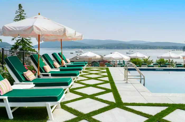 Emerald lounge chairs beside the pool with a view of the ocean