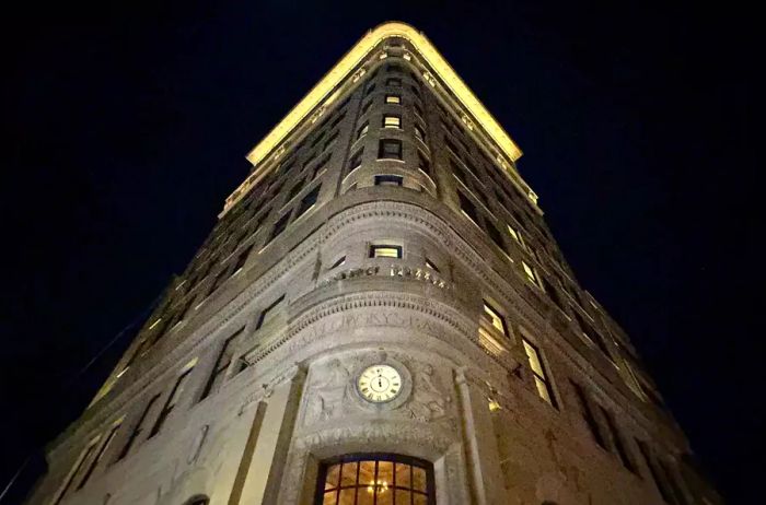 Nighttime view of the Nine Orchard hotel, a historic building originally constructed as a bank in 1912.