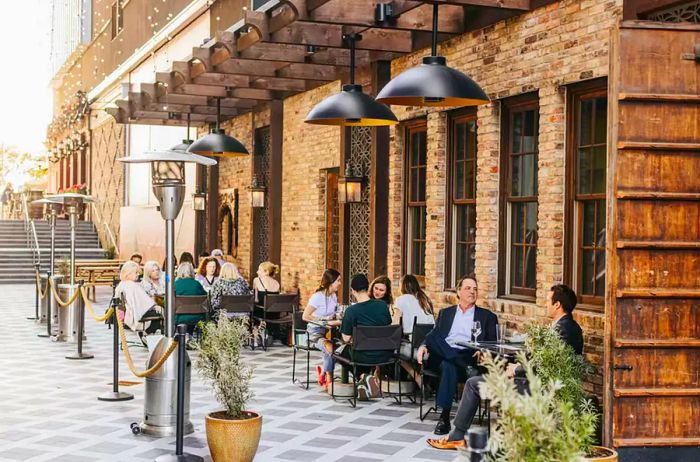 Guests relish outdoor dining experiences along La Rue Perdue in the Harwood District