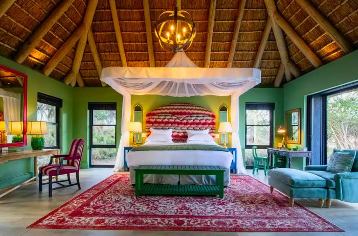 Interior guest suite featuring green walls with red accents and panoramic nature views