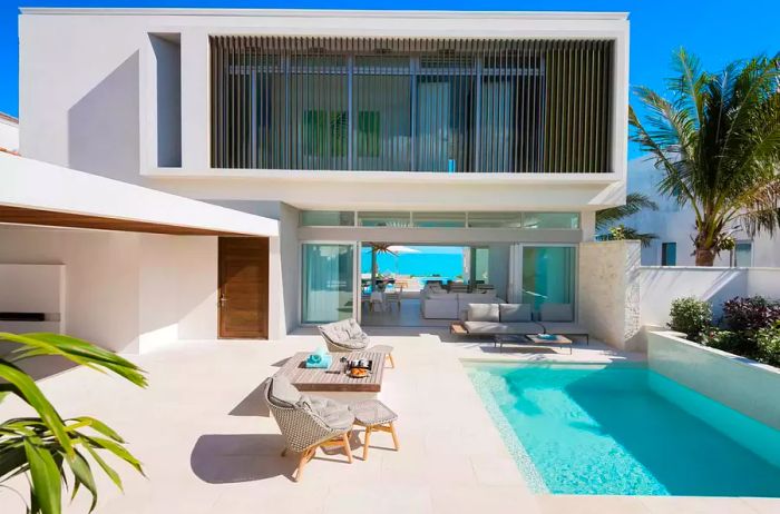 Entrance courtyard of Wymara Villas in Turks and Caicos featuring a pool with an ocean view.