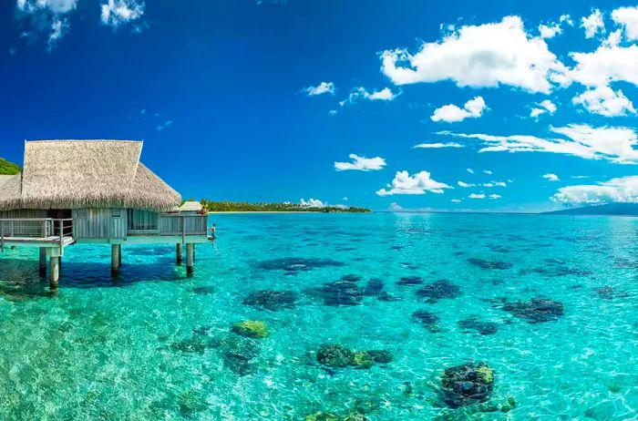 A guest enjoying the terrace of an overwater bungalow at Sofitel Kia Ora Moorea.