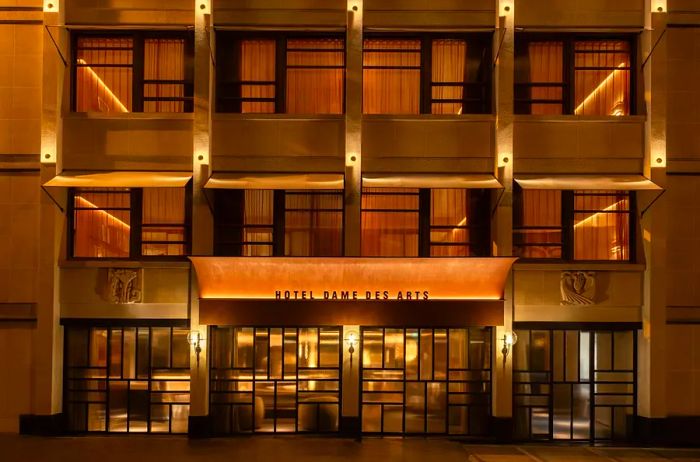 The exterior of Hôtel Dame Des Arts in Paris, France, illuminated at night