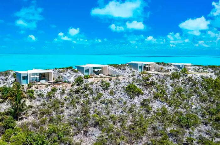 A scenic view of one-bedroom villas perched on rocky cliffs, overlooking the ocean at Wymara Villas in Turks and Caicos.