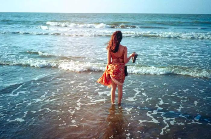 Author Ingrid Rojas Contreras wades into the waters of Cartagena, Colombia