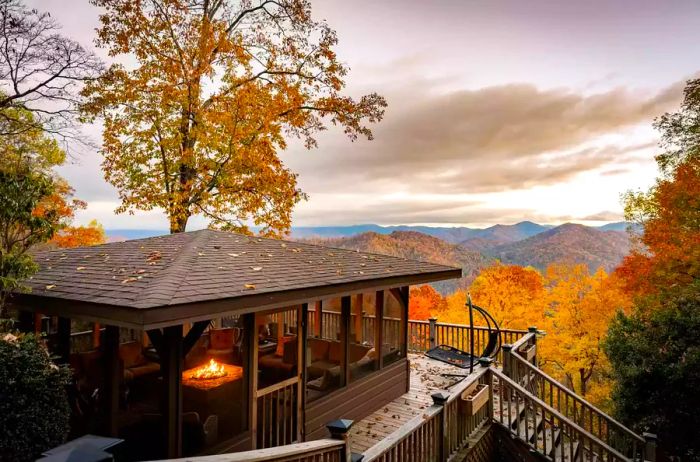 Panoramic view of the lodge featuring a fireplace and stunning autumn foliage on the mountaintops