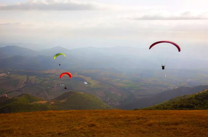 Paragliders gliding over the stunning landscapes of Umbria