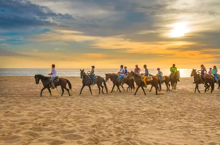 Summer at Punta Lobos Beach, where locals enjoy horseback riding in Todos Santos, Baja California Sur, Mexico.