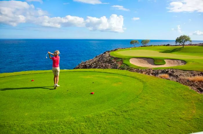 A woman enjoys golfing on The Challenge at Manele Golf Course in Lanai, Hawaii.