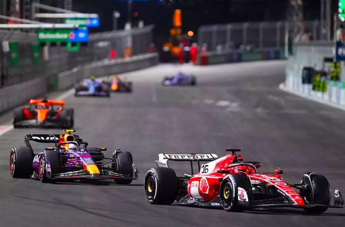 Charles Leclerc from Monaco and Ferrari, alongside Sergio Perez from Mexico and Oracle Red Bull Racing, race on track during the F1 Grand Prix of Las Vegas