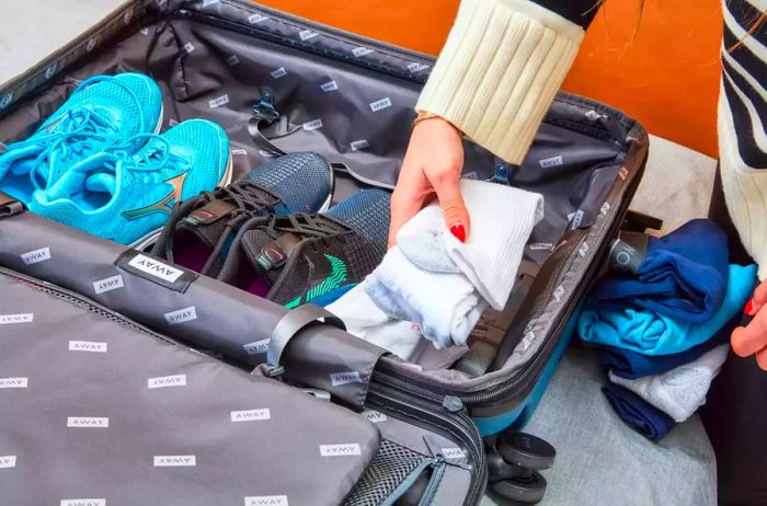 An individual organizing their belongings in the Away The Medium Flex