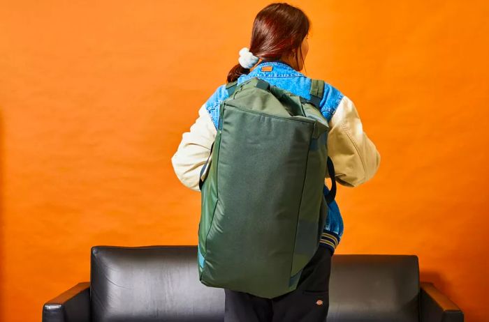 A person carries the Away F.A.R. Duffle 70L