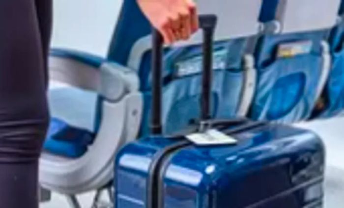 Away The Carry-On located in the aisle of the plane with a traveler