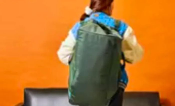 An individual carries the Away F.A.R. Duffle 70L