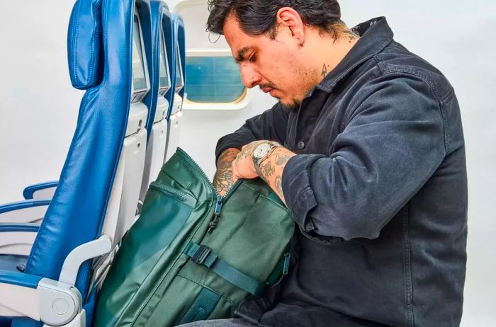 A person checks the pocket of the Away F.A.R. Convertible Backpack 45L.