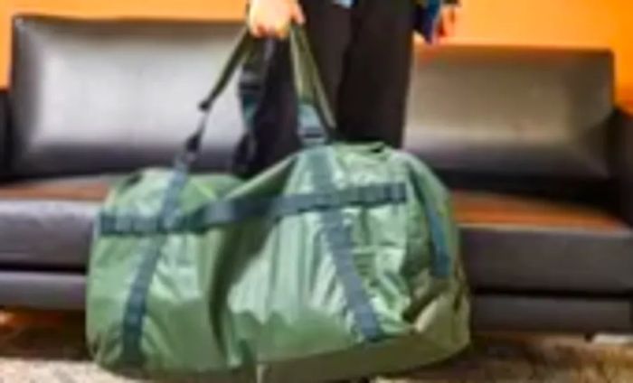 A person carries the Away F.A.R. Duffle 70L